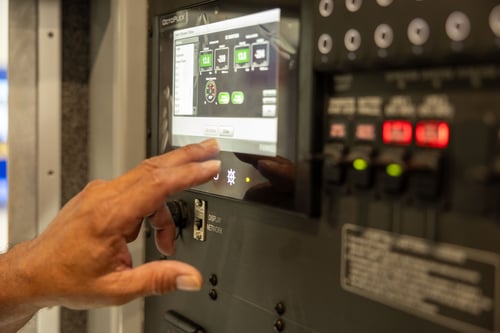 A Frontline Communications team member servicing technology on the interior of a vehicle.
