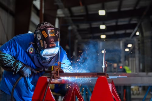 A Frontline Communications team member welding in the manufacturing facility.