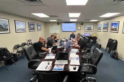Team members working in a conference room at the Frontline Communications Facility.