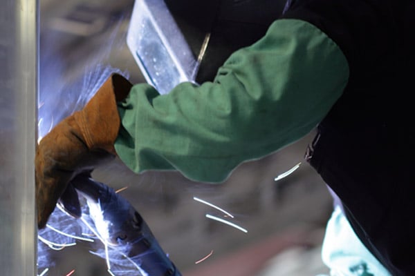 A person welding in the Frontline Communications facility.