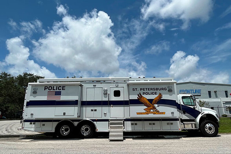 A Frontline Communications Mobile Command Vehicle for St. Petersburg Police Department parked outside on a cloudy day.
