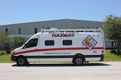 Frontline Communications white C-24 Sprinter HAZMAT Mobile Command vehicle for Pinellas County parked outside the building on a sunny day.
