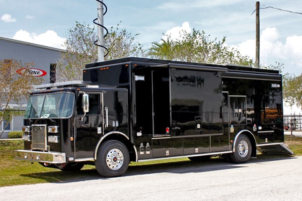 Black Mobile Command vehicle parked outside of the Frontline Communications building on a sunny day.