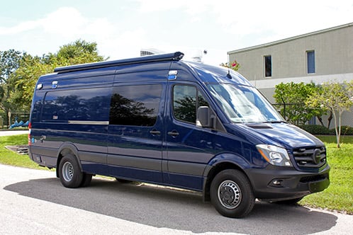 Mobile Precinct vehicle parked outside near the Frontline Communications building on a sunny day.