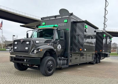 A Frontline Communications Mobile Command vehicle parked outside on a cloudy day.