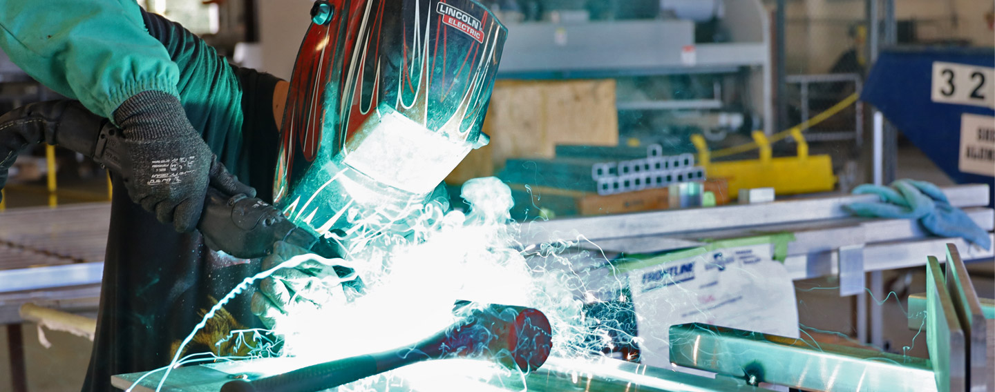 A person welding in the Frontline Communications manufacturing facility. 