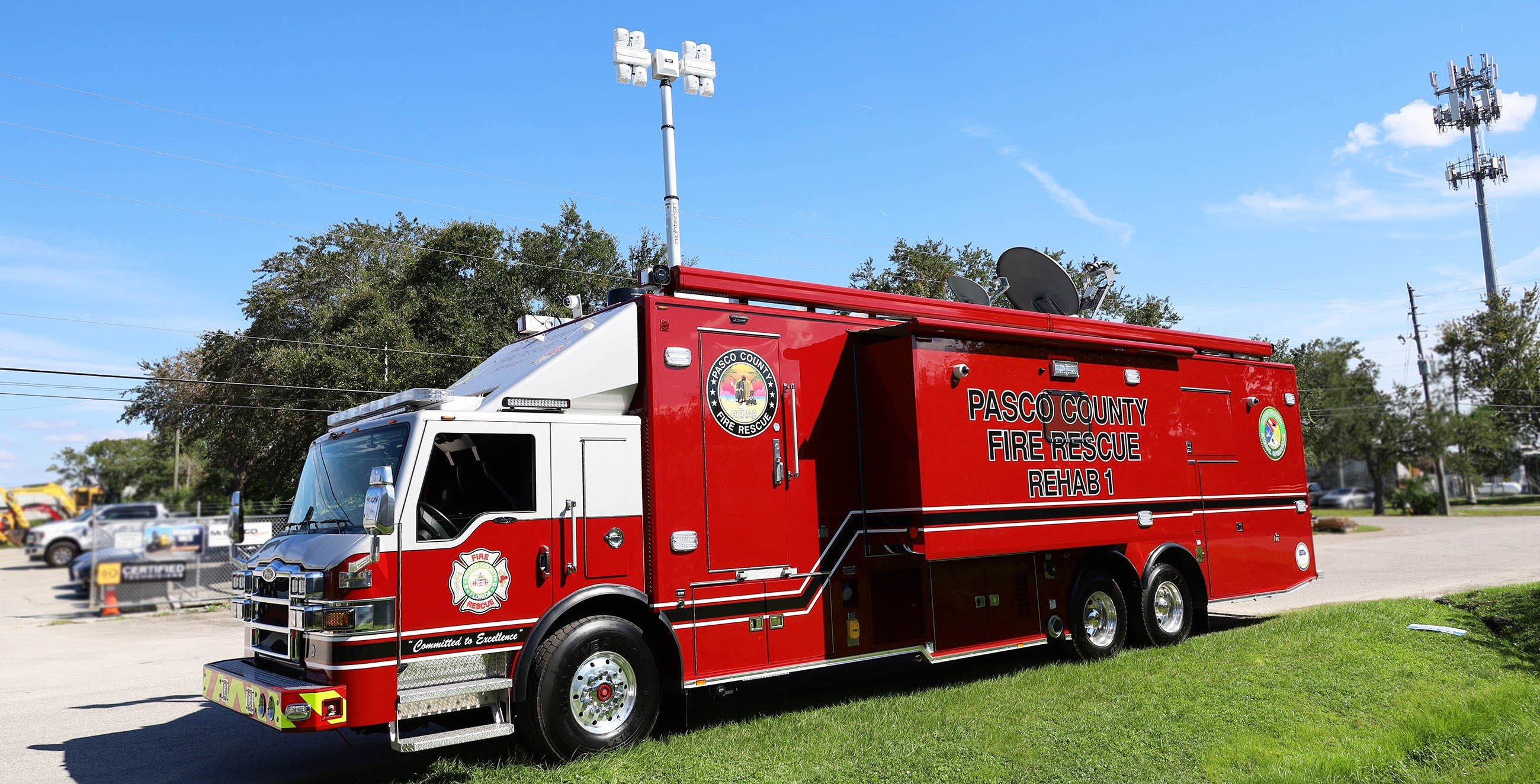 Frontline Communications Rehab unit for Pasco County Fire Rescue parked outside on the street on a sunny day. 