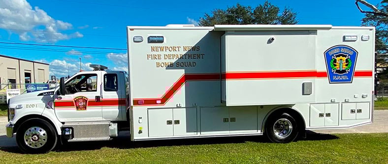 Bomb Squad vehicle for Newport News Fire Department parked outside near the Frontline Communications building on a sunny day.