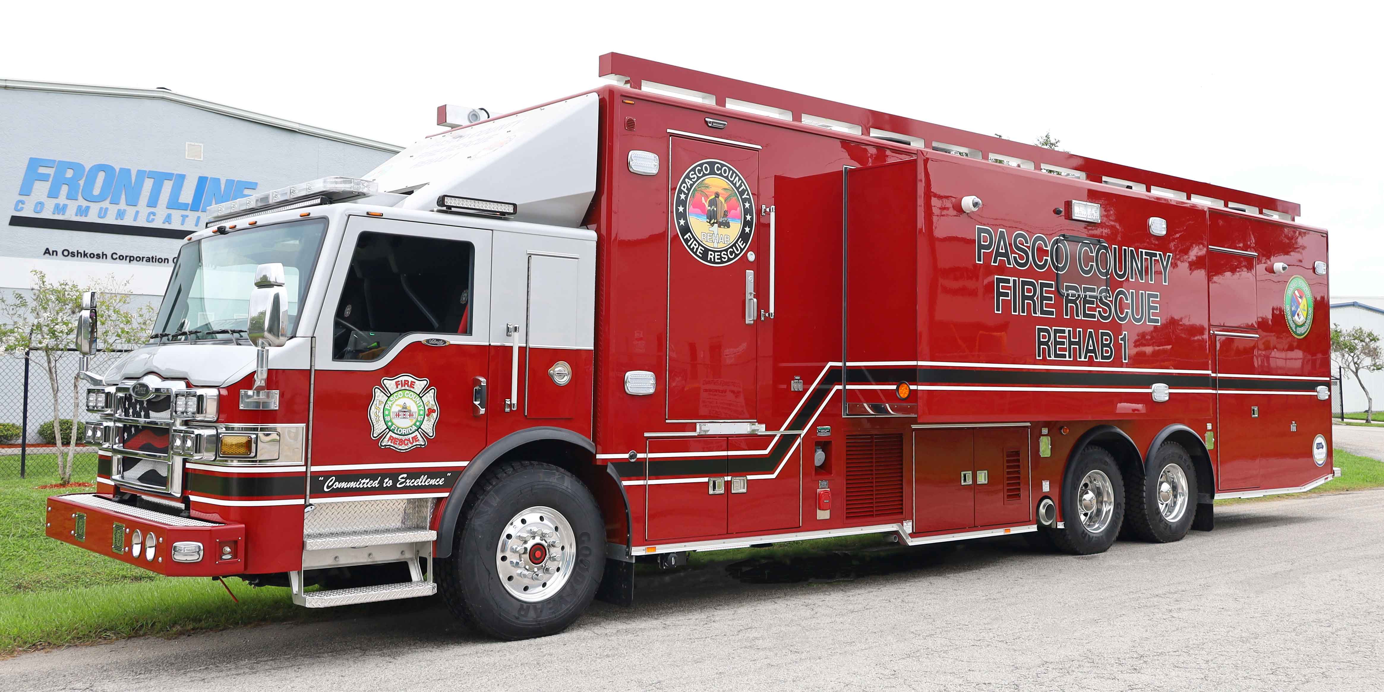 Frontline Communications Rehab Vehicle parked outside on a cloudy day.