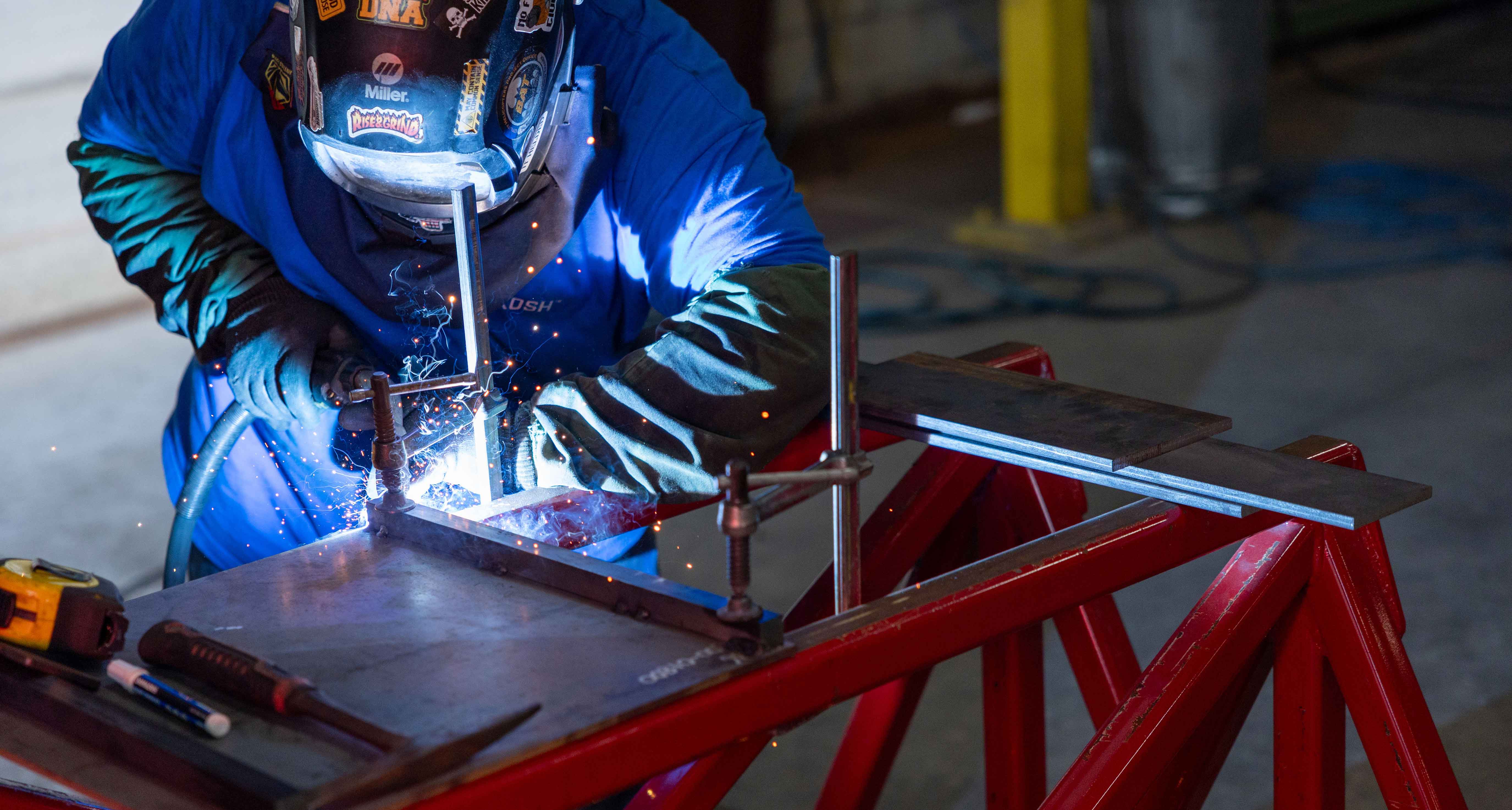 A Frontline Communications team member welding in the production facility.